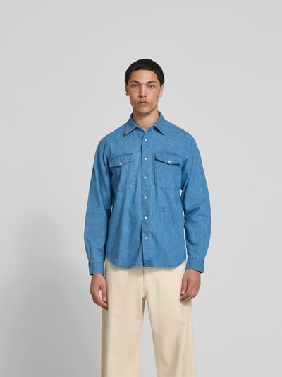 Männermodel trägt Freizeithemd in Denim-Optik von Closed aus Baumwoll-Mix mit Hanf-Anteil, Regular-Fit, zwei Brusttaschen, Langärmelig, Ganzkörperansicht von vorne.