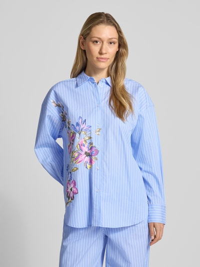 Frauenmodel trägt Regular Fit Hemdbluse mit Kentkragen von Fynch-Hatton, blau mit weißen Streifen und floralen Details, Knopfleiste, überschnittene Schultern, Sportmanschetten, Rückenlänge bei Größe 36: 71 cm, Ärmellänge bei Größe 36: 52 cm, Ganzkörperansicht von vorne.