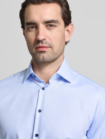 Männermodel trägt Regular Fit Business Hemd aus Baumwolle mit Kentkragen von Christian Berg Men in Hellblau, feine Textur, Nahaufnahme Oberkörper.