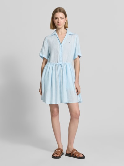 Frauenmodel trägt Ausgestelltes Freizeitkleid aus reinem Leinen von Tommy Hilfiger, Optik: Unifarben, Passform: Ausgestellt, V-Ausschnitt, Kragenform: Hemdblusenkragen, Ärmellänge: Kurzarm, Mini-Länge, Applikation: Logo-Stitching, Material: Leinen, hellblau, strukturierte Oberfläche, Ganzkörperansicht von vorne.