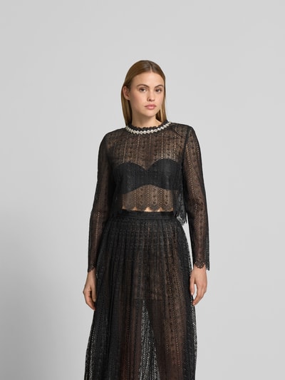 Frauenmodel trägt Slim Fit Longsleeve aus floraler Spitze von Self-Portrait aus reiner Baumwolle mit Ziersteinbesatz, Nahaufnahme Oberkörper.