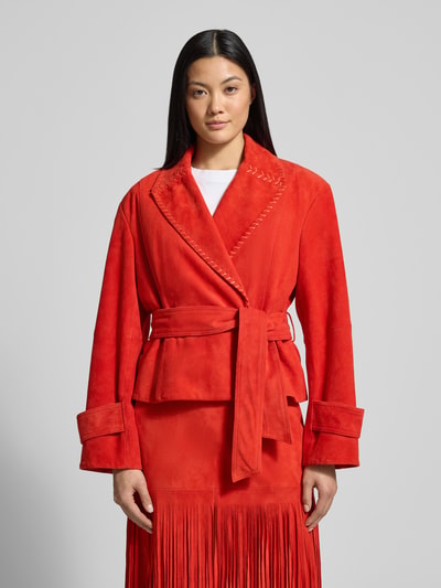 Frauenmodel trägt Lederjacke mit Bindegürtel von Marc Cain, rotes Echtleder, taillierter Schnitt, Reverskragen; Ganzkörperansicht von vorne.