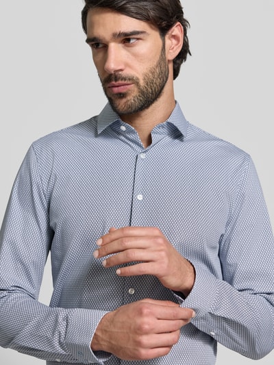 Męski model nosi Slim Fit Freizeithemd mit Kentkragen od OLYMP No. Six, mieszanka bawełny elastycznej, krój slim fit, kołnierzyk typu kent, na całej długości listwa guzikowa, z długim rękawem, sportowe mankiety, długość tyłu w rozmiarze 40: 79 cm, szerokość ramion w rozmiarze 40: 43 cm, długość rękawów w rozmiarze 40: 66 cm, drobny wzór, jasnoniebieski kolor, gładka tekstura, zbliżenie na górną część ciała.