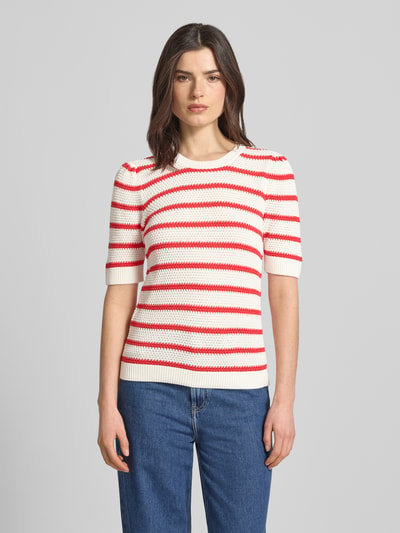 Frauenmodel trägt Strickshirt mit Rundhalsausschnitt Modell 'DALO' von Vila, Reine Baumwolle, Regular-Fit, Strukturmuster, rot-weiß, Ganzkörperansicht von vorne.