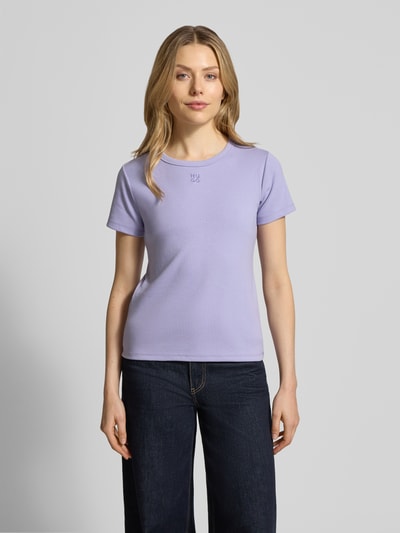 Vrouwenmodel draagt Slim Fit T-Shirt aus Baumwoll-Mix Modell 'DELORIS' van HUGO in uni-look, rondhals, korte mouw, label stitching, fijnrib-structuur, materiaal katoenmix, frontale totaalopname.