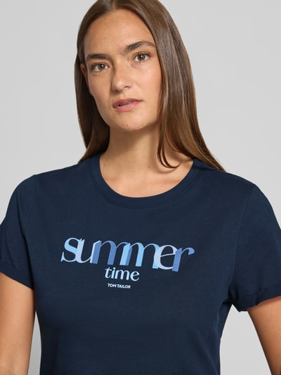 Frauenmodel trägt Regular Fit T-Shirt aus reiner Baumwolle von Tom Tailor, Optik: Unifarben, Statement-Print-Applikation, Kurzarm, Rundhals, Jersey, Nahaufnahme Oberkörper.