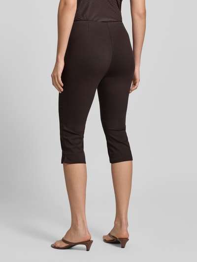 Frauenmodel trägt schwarze Strech Caprihose - curated by Mary Braun von Style Icon Collection, Baumwoll-Mix, Ganzkörperansicht Rückansicht.