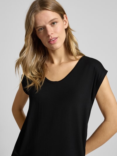 Frauenmodel trägt T-Shirt mit Stretch-Anteil Modell 'Billo' von PIECES aus Viskose-Elasthan-Mix, taillierter Schnitt, Rundhalsausschnitt, kurze Ärmel, schwarze Farbe, Nahaufnahme Oberkörper.