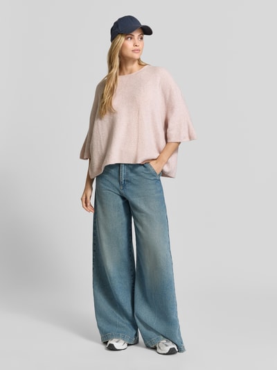 Vrouwenmodel draagt Oversized Strickpullover met Leinen-Anteil van American Vintage, Materiaalmix, oversized fit, ronde hals, halflange mouwen, geribd, ruglengte maat XS/S 50 cm, mouwlengte XS/S 54 cm, lichtroze met grove textuur, Ganzkörperaanzicht van voren.