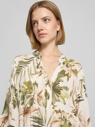 Frauenmodel trägt Midikleid aus Viskose mit Serafino-Kragen Modell 'Kl44arraa' von ZABAIONE, florales Muster, helle Farben, Nahaufnahme Oberkörper. Brustweite 53 cm, 1/2-Arm, Straight Fit, Volantsaum, Rückenlänge 113 cm.