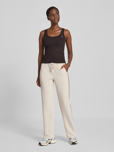 Kobiece modelka nosi top Tanktop in Ripp-Optik mit Label-Applikation Modell 'COLETTE' od GUESS Activewear, mieszanka wiskozy i elastanu, krój slim fit, efekt prążkowania, aplikacja z metką, Długość tyłu w rozmiarze S: 50 cm, widok całej sylwetki z przodu
