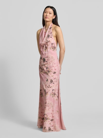 Vrouwenmodel draagt avondjurk met Neckholder en diep rugdecolleté van Mascara, roze met bloemenprint, chiffon, a-lijn, maxi-jurk, haakjessluiting, loopsplit, ritssluiting, ruglengte maat 36: 144 cm, borstwijdte maat 36: 37 cm, geheelopname vooraan.