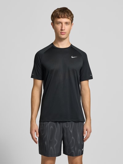 Männermodel trägt Regular Fit Sport-T-Shirt mit reflektierenden Elementen von Nike in Schwarz, glatte Struktur, Ganzkörperansicht von vorne, Herren Sport-T-Shirt von Nike Training.