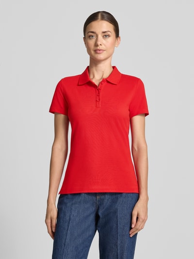 Frauenmodel trägt Regular Fit Poloshirt aus reiner Baumwolle von Tom Tailor in Rot, kurze Ärmel, glatte Struktur, Ganzkörperansicht von vorne, Damen Poloshirt von Tom Tailor.