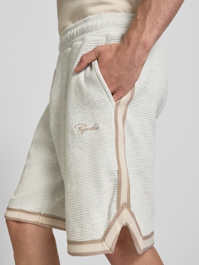 Männermodel trägt Shorts mit Strukturmuster und Label-Stitching von PEGADOR aus Reiner Baumwolle, Regular-Fit, Eingrifftaschen, Nahaufnahme Oberschenkel.