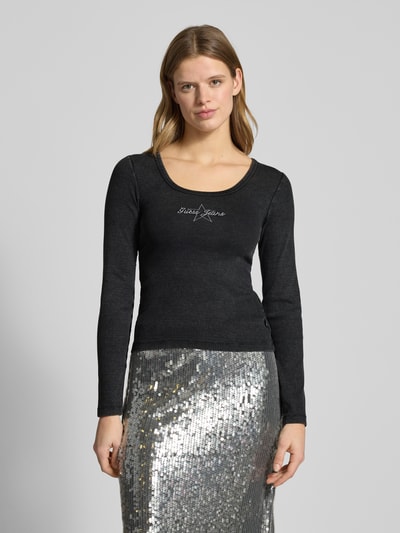 Vrouwenmodel draagt Longsleeve met Labeldetail van Guess Jeans, zwart, slim fit, mix van katoen en elastaan, ronde hals, ruglengte maat S 58 cm, voorkant bovenlichaam close-up.