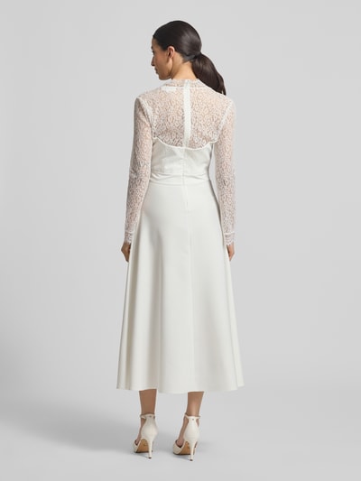 Frauenmodel trägt Tailliertes Brautkleid mit V-Ausschnitt Modell 'Joanna' von GUIDO MARIA KRETSCHMER WOMAN, Spitze, Langärmelig, Rückansicht Ganzkörperansicht.