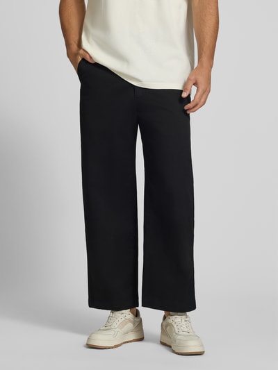 Männermodel trägt Loose Fit Weite Hose aus Baumwoll-Mix von Lacoste, Schwarz, gerade Form, glatte Textur, Nahaufnahme Unterkörper, Herren Weite Hose von Lacoste.