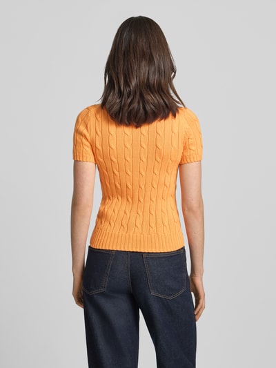 Frauenmodel trägt Slim Fit Kurzarmpullover mit Label-Stitching von Polo Ralph Lauren in Orange, Strick-Optik, Reine Baumwolle, Brusttasche, Rundhalsausschnitt, elastische Abschlüsse; Ganzkörperansicht Rückansicht.