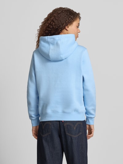 Frauenmodel trägt Regular Fit Hoodie aus Baumwoll-Mix von Tommy Jeans in Hellblau, Optik: Unifarben, Ganzkörperansicht Rückansicht.