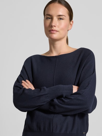 Frauenmodel trägt Strickpullover aus Viskose-Mix von MORE & MORE in Dunkelblau mit U-Boot-Ausschnitt, Nahaufnahme Oberkörper.