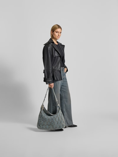 Frauenmodel trägt Shoulder Bag in Denim-Optik von Diesel mit Ketten-Optik und Strasssteinbesatz, Ganzkörperansicht von vorne.