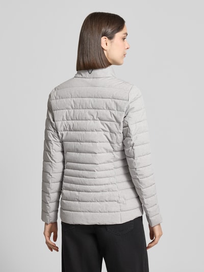 Kobiece modelka nosi kurtka pikowana Steppjacke mit Reißverschlusstaschen Modell 'GS 111' von G.I.G.A. DX, kolor jasnoszary, krój slim fit, stójka, zamek błyskawiczny, kieszenie zapinane na zamek błyskawiczny, długość tyłu w rozmiarze 36: 67 cm, szerokość ramion w rozmiarze 36: 38 cm, szerokość w rozmiarze 36: 49 cm, długość rękawów w rozmiarze 36: 65 cm, całkowity widok z tyłu.