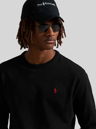 Męski model nosi Bluzka z długim rękawem mit Label-Stitching von Polo Ralph Lauren z bawełny, krój regular fit, prążkowane wykończenia, okrągły dekolt, wyhaftowane logo, długość tyłu w rozmiarze M: 68 cm, kolor czarny, prosty materiał, Nahaufnahme górnej części ciała.