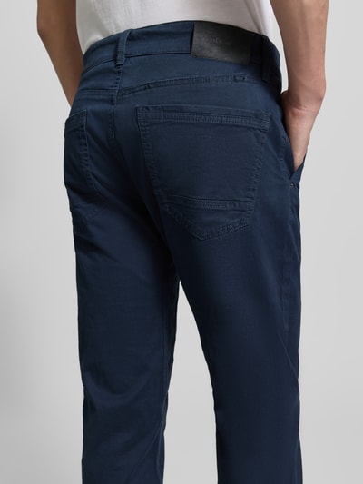 Männermodel trägt Regular Fit Chino aus Baumwoll-Mix von s.Oliver RED LABEL, efekt: jednolity kolor, naszywka z logo, 5 kieszeni, mieszanka bawełny, Ganzkörperansicht Rückansicht.