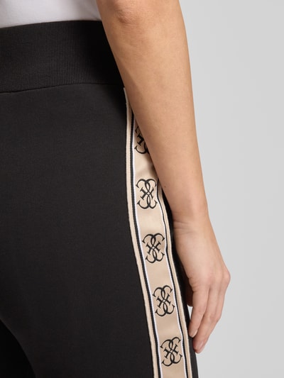 Frauenmodel trägt schwarze Sweatpants mit elastischem Bund Modell 'BRITNEY' von Guess, Baumwoll-Mix, Detailaufnahme Hüfte