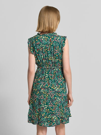 Frauenmodel trägt Minikleid aus reiner Viskose mit floralem Allover-Print von Apricot, taillierte Passform, Rückenansicht, Ganzkörperansicht Rückansicht.