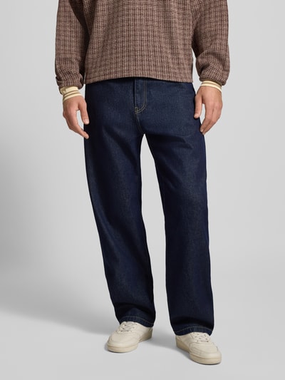 Mężczyznny model nosi Jeans mit weitem Bein Modell 'LANDON' od Carhartt Work In Progress, ciemnoniebieski denim, szerokie nogawki, widok z przodu, ujęcie całej sylwetki.