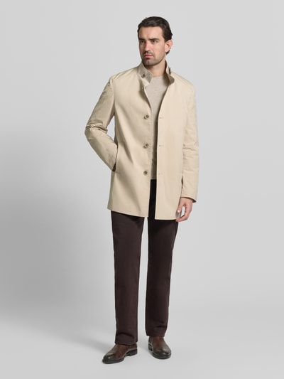 Männermodel trägt Mantel mit durchgehender Knopfleiste von CINQUE in Beige, mit Stehkragen, Eingrifftaschen, Gerade Passform, Ganzkörperansicht von vorne. Rückenlänge 83 cm, Schulterbreite 42 cm, Brustweite 40 cm, Ärmellänge 66 cm bei Größe 50.