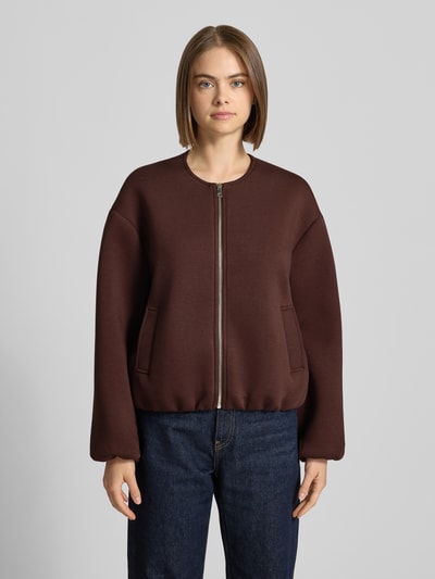 Modelka nosi brązową bluzę rozpinaną z dodatkiem wiskozy Regular Fit Sweatjack mit Viskose-Anteil model 'LELLIE' od ONLY, damska bluza rozpinana, widok całej sylwetki z przodu.