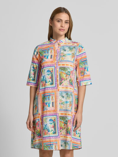 Frauenmodel trägt Knielanges Kleid aus reiner Viskose von Emily Van den Bergh, bunt mit lockerem Schnitt, Stehkragen, Knopfleiste, 3/4-Arm, Ganzkörperansicht von vorne. Rückenlänge bei Größe 36: 103 cm, Brustweite: 49 cm, Ärmellänge: 40 cm.