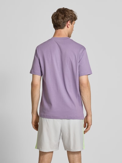 Männermodel trägt T-Shirt mit Logo und Rundhalsausschnitt von New Balance aus reiner Baumwolle, Regular-Fit, Rückenlänge 74 cm, Ganzkörperansicht Rückansicht.