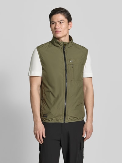 Männermodel trägt Regular Fit Weste mit gefüttertem Stehkragen von camel active in Olivgrün mit Brusttasche, Reißverschluss und elastischem Bund, Ganzkörperansicht von vorne. Rückenlänge 64 cm, Schulterbreite 45 cm, Brustweite 60 cm bei Größe M.