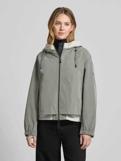 Frauenmodel trägt Jacke mit Zweiwege-Reißverschluss von Gil Bret in Grau, Relaxed Fit, Kapuze, Eingrifftaschen, Ganzkörperansicht von vorne.