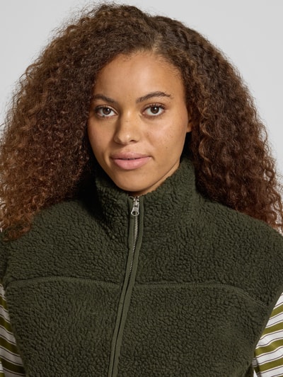 Frauenmodel trägt Relaxed Fit Weste in Teddy-Optik Modell 'SADIA' von PIECES in Dunkelgrün, grobe Struktur, Nahaufnahme Oberkörper, Damen Weste