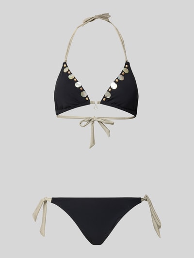 Frauenmodel trägt Bikini mit Schnürung Modell 'YERODASIA KERANGA' von Banana Moon, Schwarz mit Gold, Material-Mix mit Stretch-Anteil, Seitliche Schnürung, Körpernahe Passform, Label-Detail, Ganzkörperansicht von vorne.