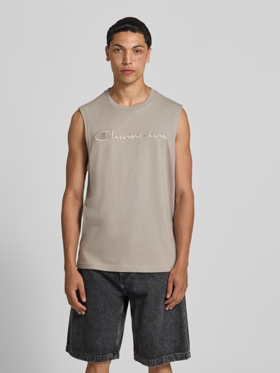 Männermodel trägt Top mit Label-Stitching und Rundhalsausschnitt von CHAMPION aus Reine Baumwolle, Regular-Fit, sandfarben, Ganzkörperansicht von vorne.