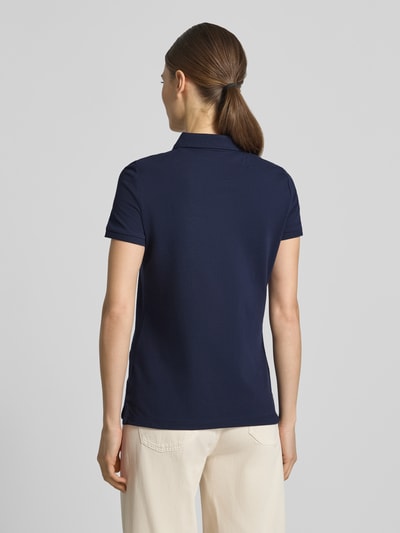 Frauenmodel trägt Slim Fit Poloshirt mit Knopfleiste von Christian Berg Woman aus Baumwoll-Elasthan-Mix, dunkelblau, Rückenansicht, Rückenlänge bei Größe S 62 cm, mit Seitenschlitze.