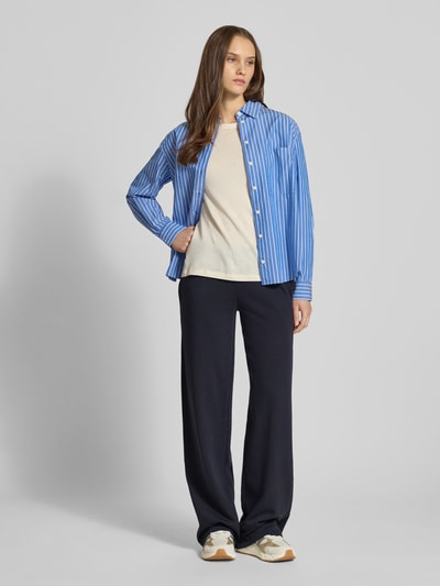 Frauenmodel trägt Wide Fit Sweatpants mit Viskose-Anteil von Review, dunkelblauer Baumwoll-Mix, elastischer Bund mit Tunnelzug, Ganzkörperansicht von vorne. Innenbeinlänge bei Größe S: 89 cm.