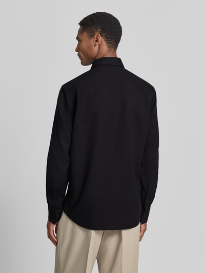 Männermodel draagt Regular Fit vrijetijdsoverhemd uit katoenmix model 'RELEGANT_2_M' van BOSS Orange in effen kleuren, achterpas en labelpatch, lange mouwen, kentkraag, doorlopende knoopsluiting, piqué textuur, achteraanzicht.