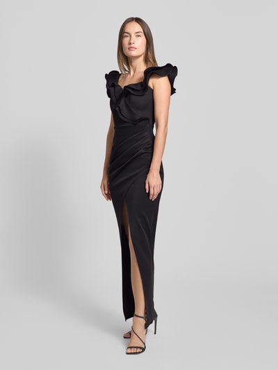 Frauenmodel trägt Abendkleid mit Volants von Lipsy in Schwarz, taillierter Schnitt, Square-Neck, Gehschlitz, Ganzkörperansicht von vorne.