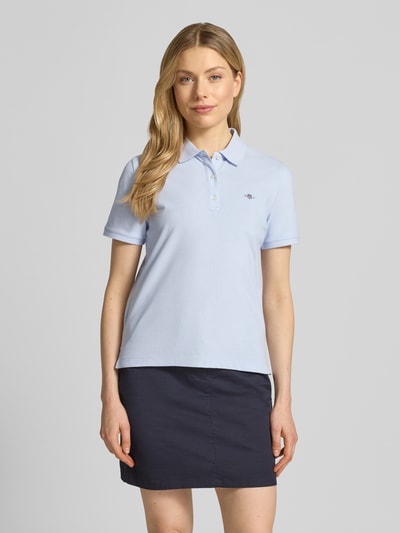 Frauenmodel trägt Poloshirt mit Logo-Stitching und Polokragen von Gant aus Reine Baumwolle im Regular-Fit, Ganzkörperansicht von vorne.