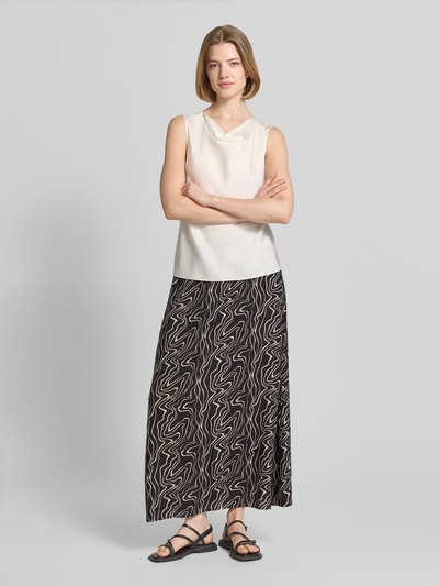 Frauenmodel trägt Ausgestellter Maxi-Rock aus reiner Viskose Modell 'EASY JOY' von Vero Moda mit grafischem Allover-Muster in Schwarz und Weiß, Popeline-Struktur, elastischer Bund, Ganzkörperansicht von vorne.
