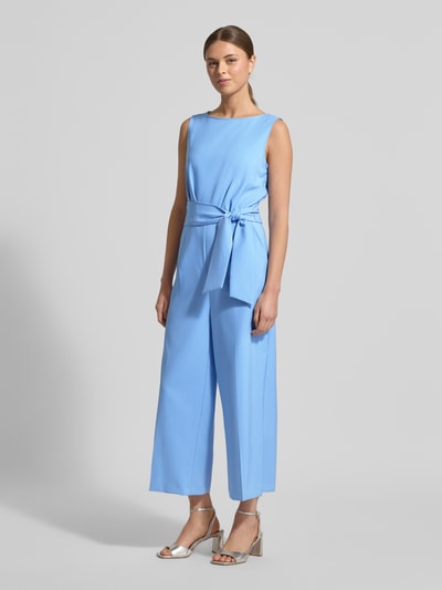 Frauenmodel trägt Jumpsuit mit Bindegürtel von Betty Barclay aus blauem Material-Mix mit Stretch-Anteil, weite Beine, Rundhalsausschnitt, Ganzkörperansicht von vorne.