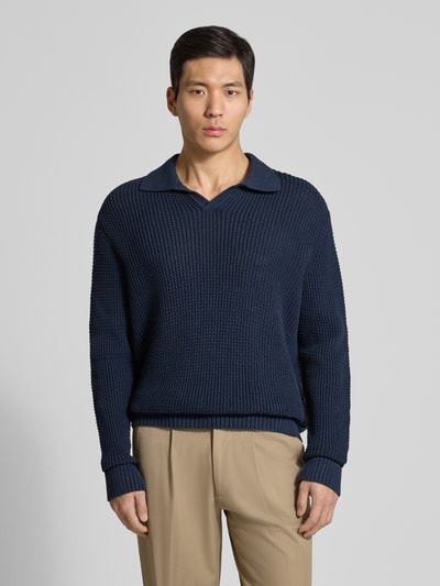 Männermodel trägt Relaxed Fit Strickpullover aus reiner Baumwolle Modell 'DERECK' von Selected Homme, unifarben, Grobstrick, Ganzkörperansicht von vorne.