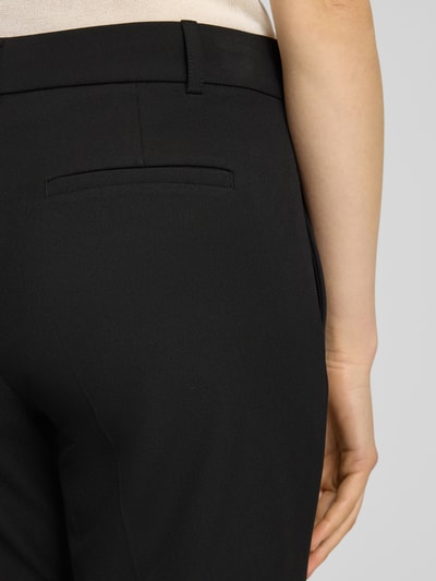 Kobieta prezentuje Hose mit Bügelfalten und Gesäßtasche von Christian Berg Woman Selection, czarny kolor, mieszanka materiałów z dodatkiem wiskozy, krój regular fit, kanty, kieszeń z tyłu, długość wewnętrzna nogawki 80 cm, szerokość w rozmiarze 36: 42 cm, detailaufnahme tył.